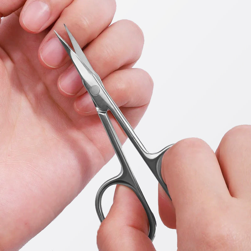 une femme utilise les ciseaux cuticules courbes pour couper ses cuticules, fond blanc